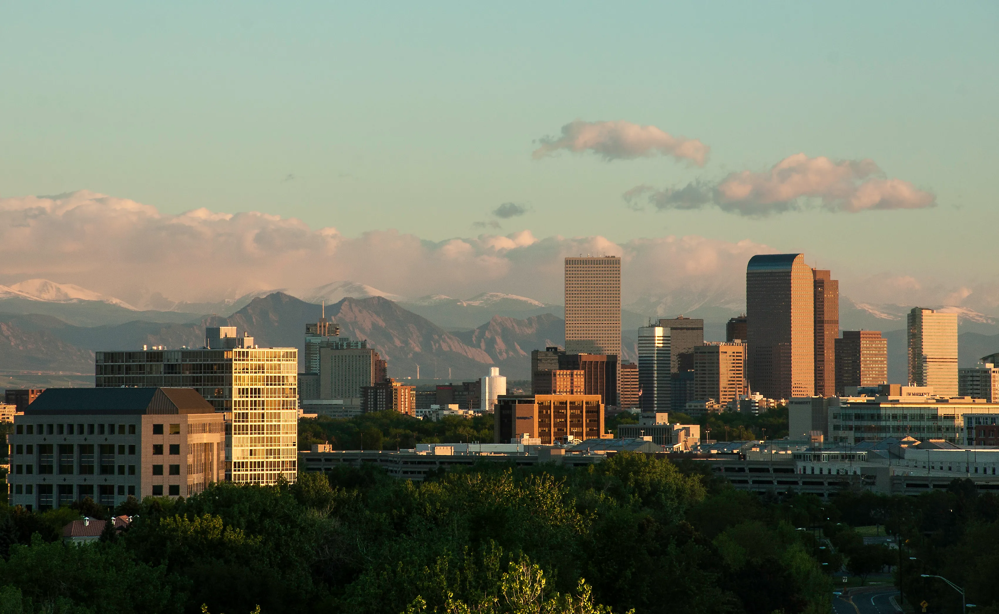 Downtown Denver skyline at dusk with the Front Range behind it